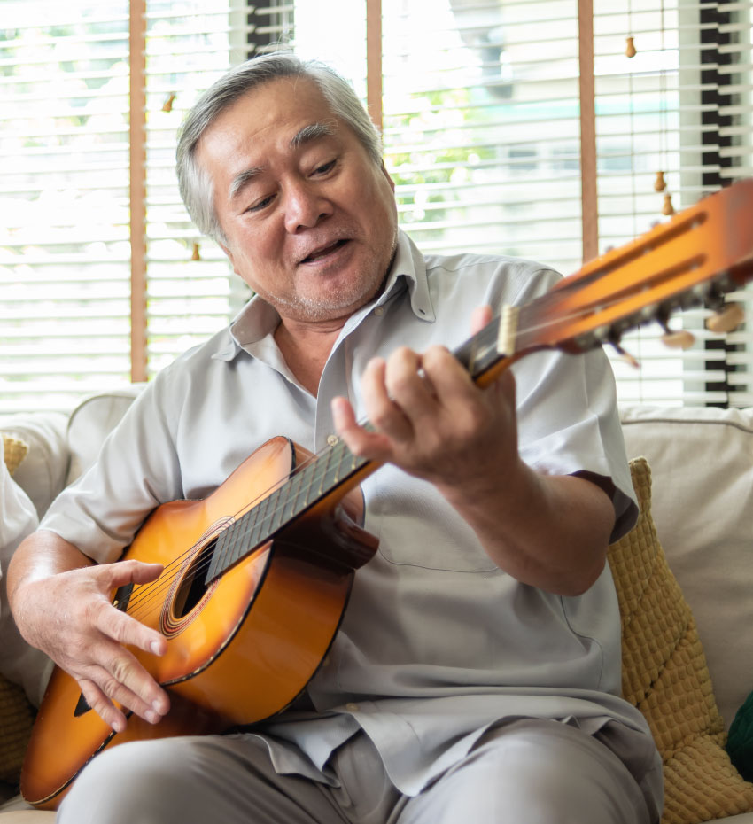 ギターを弾くシニア男性